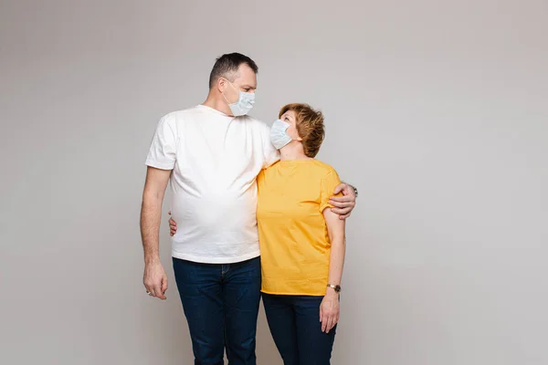 Man in chirurgische masker knuffelen vrouw in studio — Stockfoto