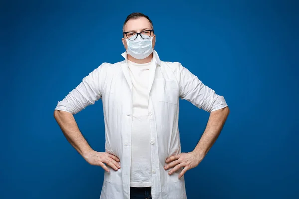 Дорослий лікар стоїть в захисній масці для обличчя в студії — стокове фото