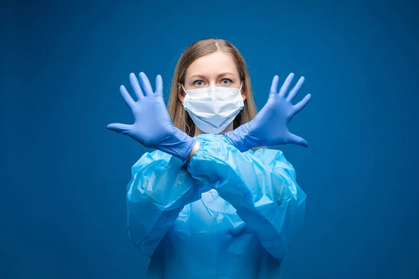 Porträtt av vacker flicka med långt ljust hår med medicinsk mask i ansiktet, bild isolerad på blå bakgrund — Stockfoto