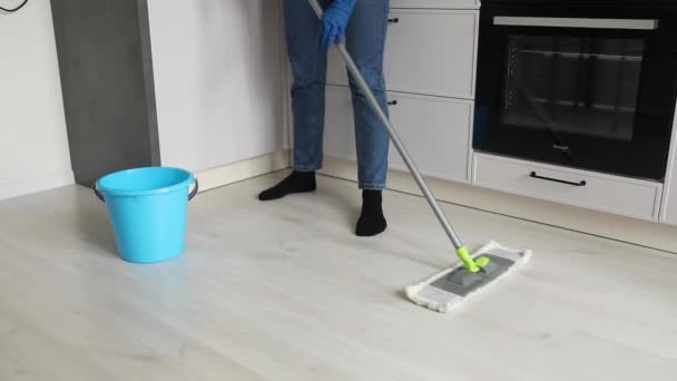 Un hombre lava el suelo en la cocina — Vídeo de stock