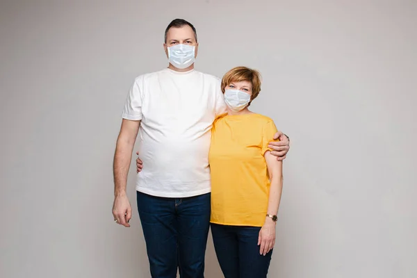 Volwassen paar in maskers omhelzen elkaar. — Stockfoto