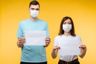 Boş pankartlı maskeli bir çift. Stüdyo stoğunda kadın ve erkeğin fotoğrafı