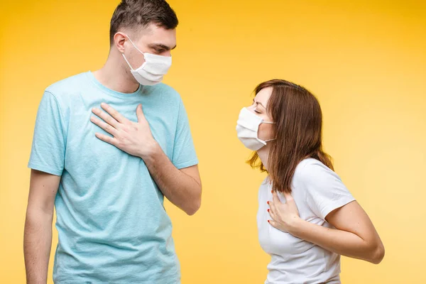 Paar in steriele ademhalingstoestellen houdt handen op de borst. — Stockfoto