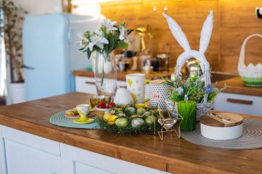 Limonlar, zeytinler, tahtanın üzerinde badem, arkada Paskalya yumurtaları.