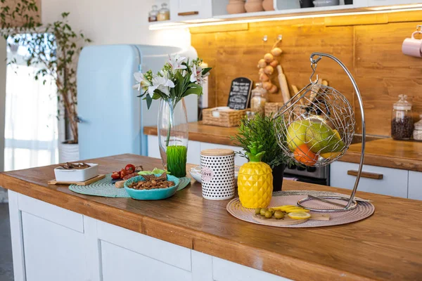 Groene appel, peer en sinaasappel mandarijn zijn in een metalen hangende vaas in de keuken — Stockfoto