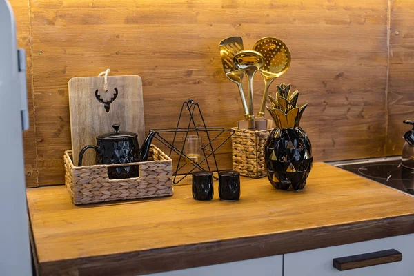 Ouro e preto utensílios de cozinha diferentes na mesa marrom — Fotografia de Stock
