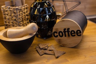 Havan topu, tokmak ve kahve kabı masanın üstünde..