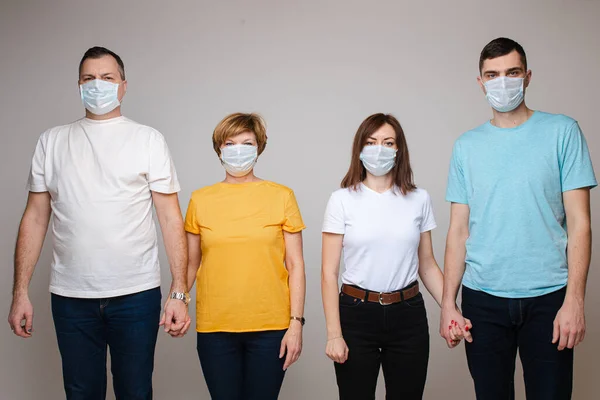 Vier volwassenen met maskers die samen tegen het virus vechten. — Stockfoto