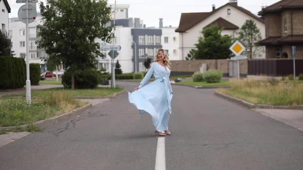 Όμορφη ξανθιά γυναίκα με φόρεμα χορεύει στο δρόμο. — Αρχείο Βίντεο