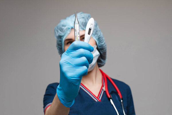 Portrait of female doctor in medical clothes with phonendoscope around her neck holds several test tubes, picture isolated on white background