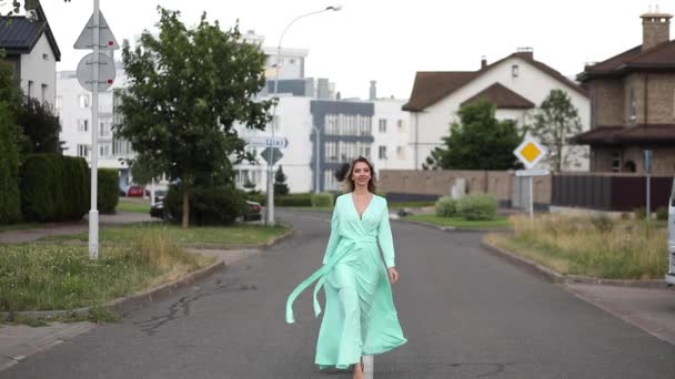 Incognito girl in mint dress dancing in the street. — Stock Video