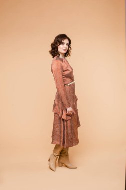 Klasik giyimli, kemerli ve çizmeli şık bir manken..