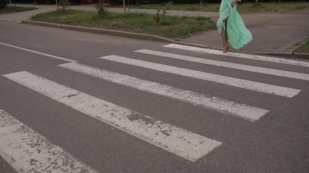 Schöne Frau in langem Minzkleid und mit weißem Hut geht auf der Straße in der Landschaft — Stockvideo