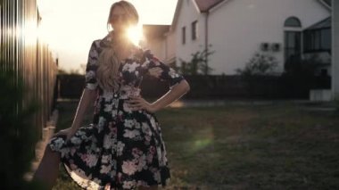 Güzel, uzun sarı saçlı, siyah elbiseli ve gülümseyen neşeli bir kadın.