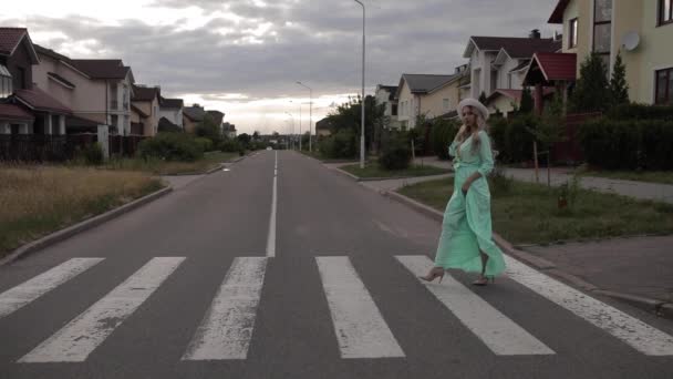 Bella donna in abito lungo menta e con cappello bianco passeggiate per strada in campagna — Video Stock