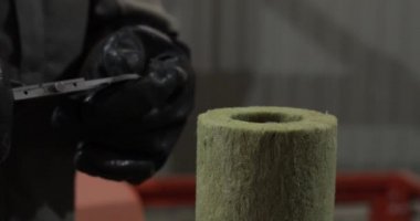 Özel siyah eldivenli bir işçi, kalibreli bir boru yalıtımının çapını ölçer.