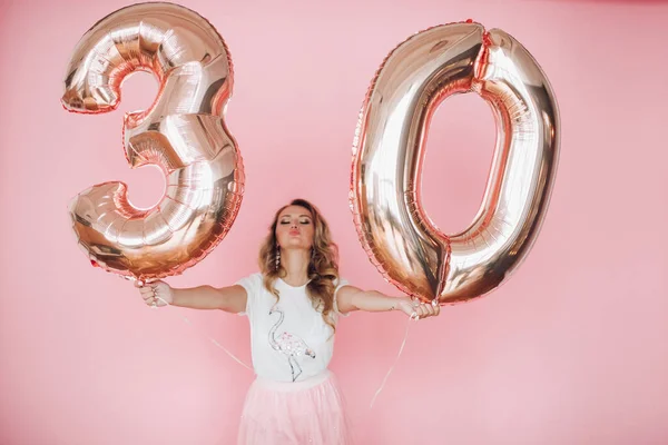 Attrayant jeune fille en vêtements d'été a donné beaucoup de plaisir et célèbre son anniversaire, image isolée sur fond rose — Photo