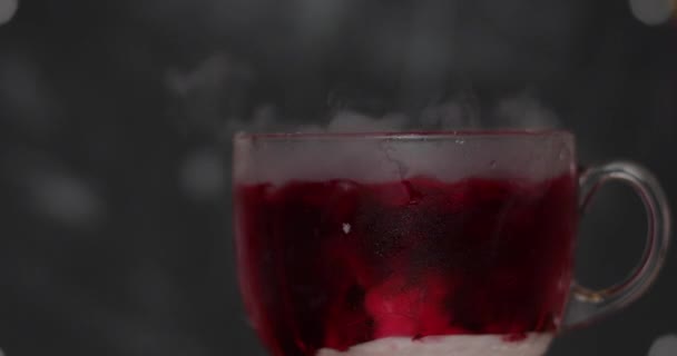 Many pieces of dry ice lie in a glass cup and are filled with water — Stock Video