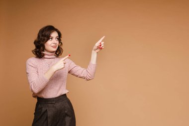 Pembe kazaklı şık kadın boş bir yeri işaret ediyor..