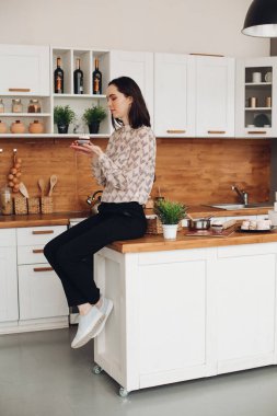 Hamdsome 'lı genç kadın lokum yaptı ve büyük parlak mutfağında yedi.