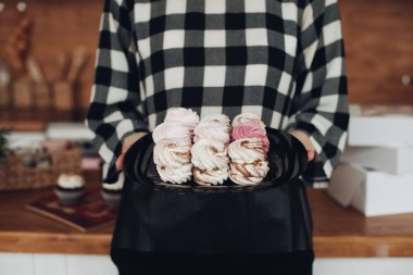 Çekici kadın marşmelov yaptı, onları bir kutuya koydu ve büyük parlak mutfağında gösterdi.