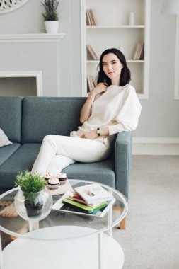 Oturma odasındaki kanepede güzel genç bir kadın..