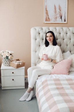 Güzel bir kadın yatak odasında sabah çayını ya da kahveyi sever..