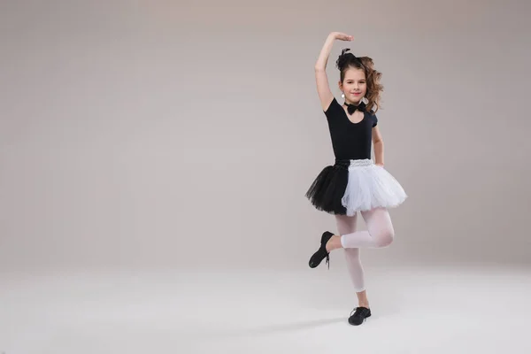 छोटी बेबी लड़की बैलेरिना काले और सफेद कपड़ों में नृत्य करते हुए मुस्कुराते हुए सकारात्मक भावना — स्टॉक फ़ोटो, इमेज