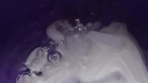 Molti pezzi di ghiaccio secco si trovano in un piatto blu e sono riempiti con acqua — Video Stock