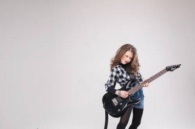 Sevimli bebek rock yıldızı elektro gitar çalıyor ve balonlarla çevrili şarkılar söylüyor.