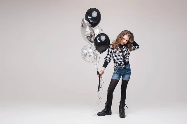 Cooles Pre-Teen Mädchen mit Rock-Zeichen. Sie zeigt Rock n Roll oder Hupzeichen, gestikuliert in die Kamera und schmückt ihre Lippen mit zwei Luftballons. Stock Studio Portrait isoliert auf grau. — Stockfoto