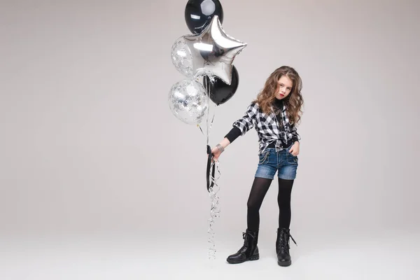 Bella ragazza pre-adolescente con segno di roccia. Sta mostrando il segno del rock n roll o del corno, gesticolando verso la telecamera e imbronciandosi le labbra con due palloncini d'aria. Stock studio ritratto isolato su grigio . — Foto Stock