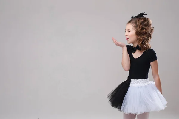 Klein meisje poseren met haar been omhoog in dansen kostuum. — Stockfoto