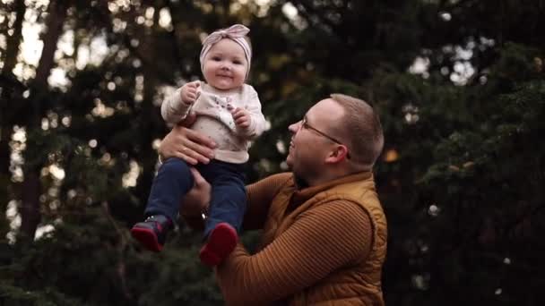 Sevgi dolu anne kızını babasının elleriyle parkta öpüyor.. — Stok video