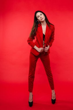 Ofis dergisi için güzel bir kadın poz veriyor, kırmızı arka planda izole edilmiş bir resim.