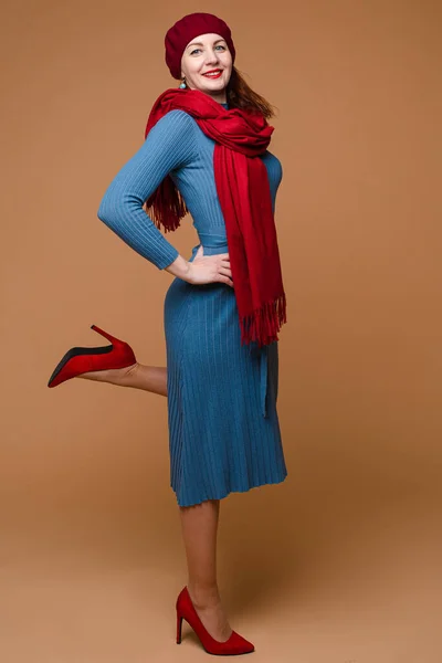 파란색 옷을 입은 중간검은 머리에 빨간 모자와 빨간 스카프를 한 아름다운 코카서스 암컷의 모습 — 스톡 사진