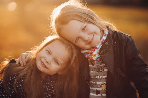 Twee mooie zusjes staan en knuffelen elkaar — Stockfoto