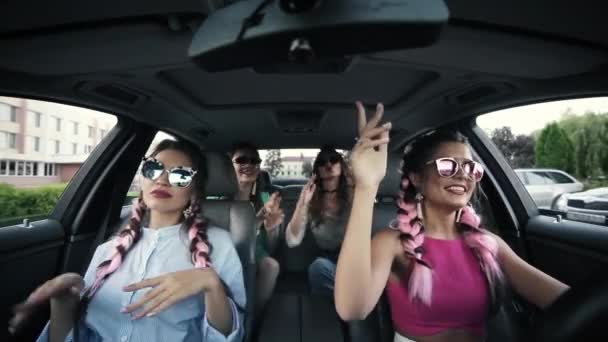 Cuatro amigas felices en gafas de sol divirtiéndose en el coche . — Vídeo de stock