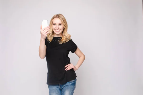 Menina bonita apontando para o telefone celular.Estúdio retrato de belo caucasiano — Fotografia de Stock