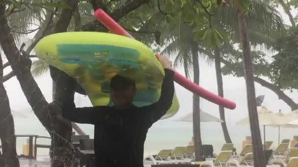 Hombre atrapado en la lluvia tropical de Tailandia — Vídeo de stock