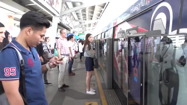 BANGKOK - 17 DIC 2016: Commuters hop on the BTS Skytrain — Vídeos de Stock