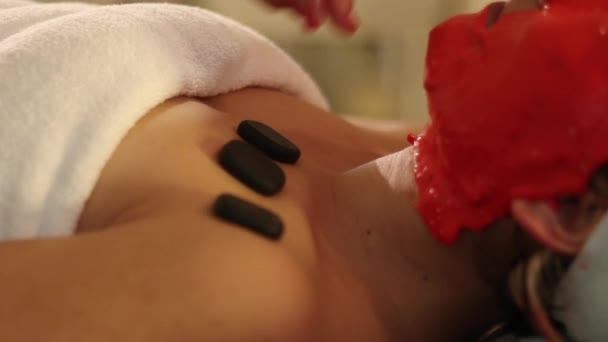 Mascarilla facial y piedras calientes en el tratamiento de spa de mama — Vídeo de stock