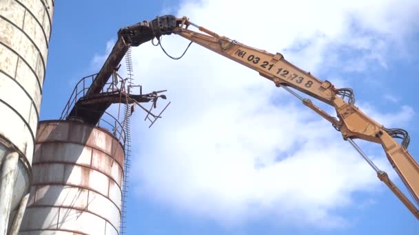 Бульдозер уничтожает старую металлическую силосную башню — стоковое видео