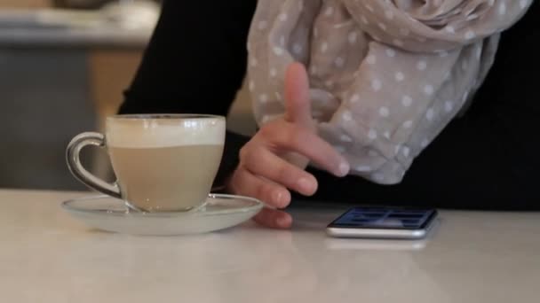 Женщина использует смартфон в кафе крупным планом — стоковое видео