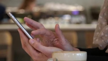 Kadın dokunmatik akıllı telefon ekran bir kafede