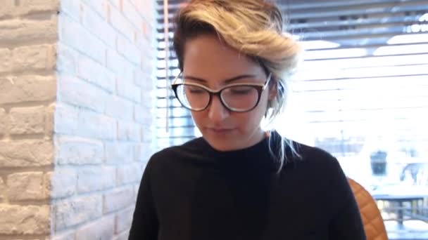 Ελκυστική γυναίκα με γυαλιά με γραφομηχανή — Αρχείο Βίντεο