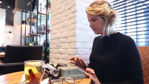 Женщина с пишущей машинкой в кафе — стоковое видео