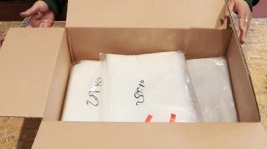 Çalışan malların karton kutular kapatır