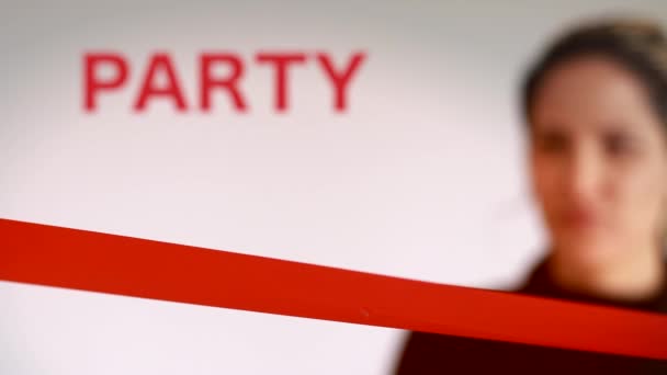Aufnahme einer Frau, die auf einer Party ein rotes Band durchschneidet — Stockvideo