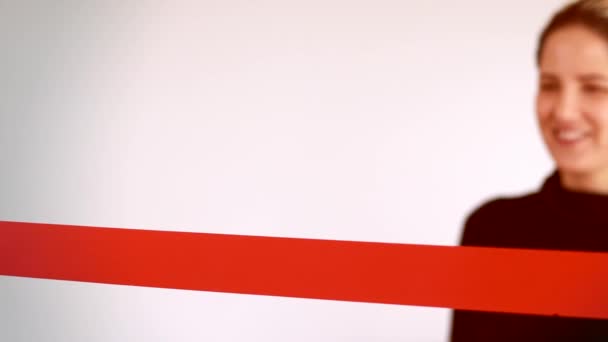 Снимок женщины, перерезающей красную ленту с копировальным местом — стоковое видео